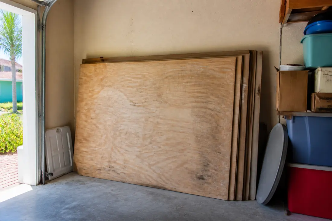 Sheets of plywood stored on edge in a garage