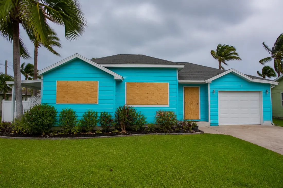 Plywood panels fastened over the windows of a Florida house before a storm