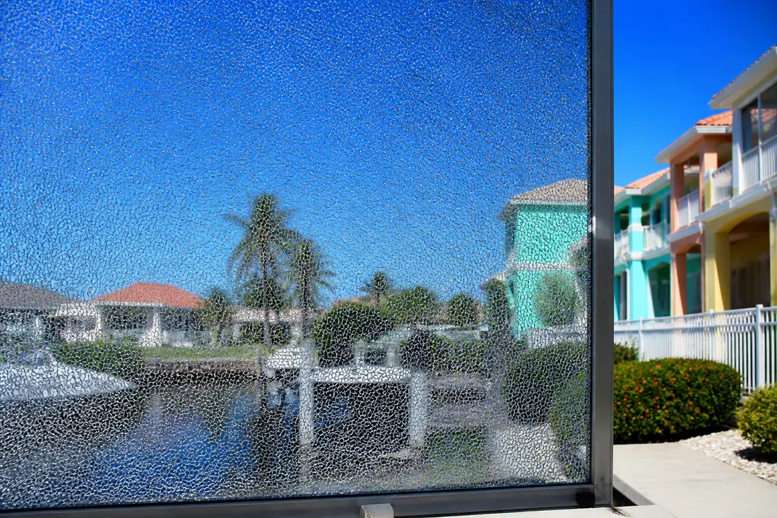 A tempered glass panel broken into small blunt fragments inside its frame