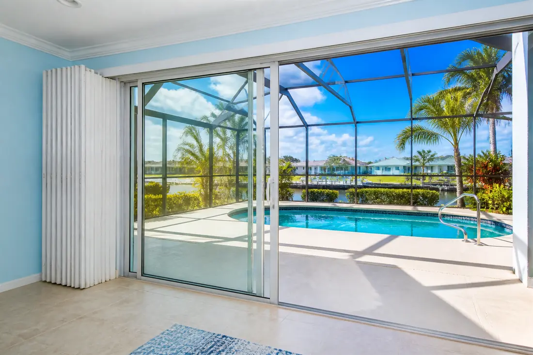 A wide sliding glass door onto a lanai with shutters mounted at the opening